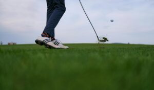 Golfer mid-swing during a pain-free round after receiving Titleist-certified physical therapy and robotic muscle treatment in Lake Orion.