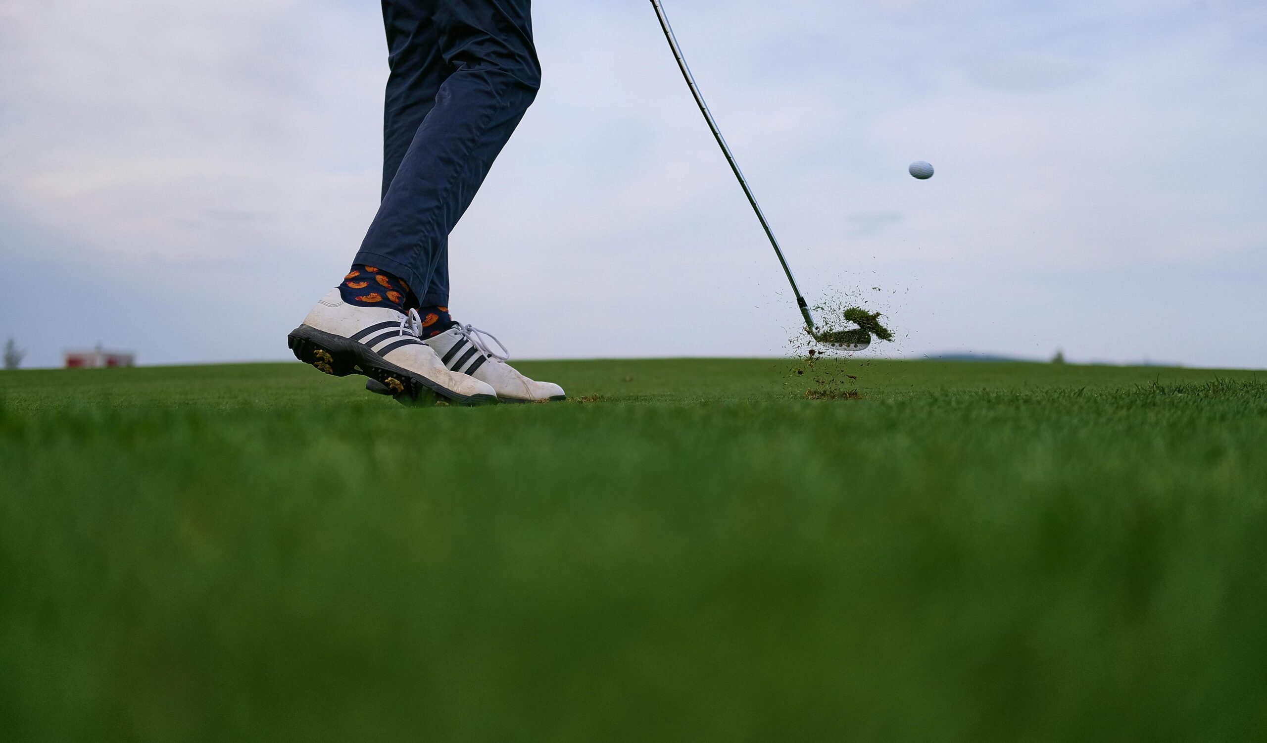 Golfer mid-swing during a pain-free round after receiving Titleist-certified physical therapy and robotic muscle treatment in Lake Orion.